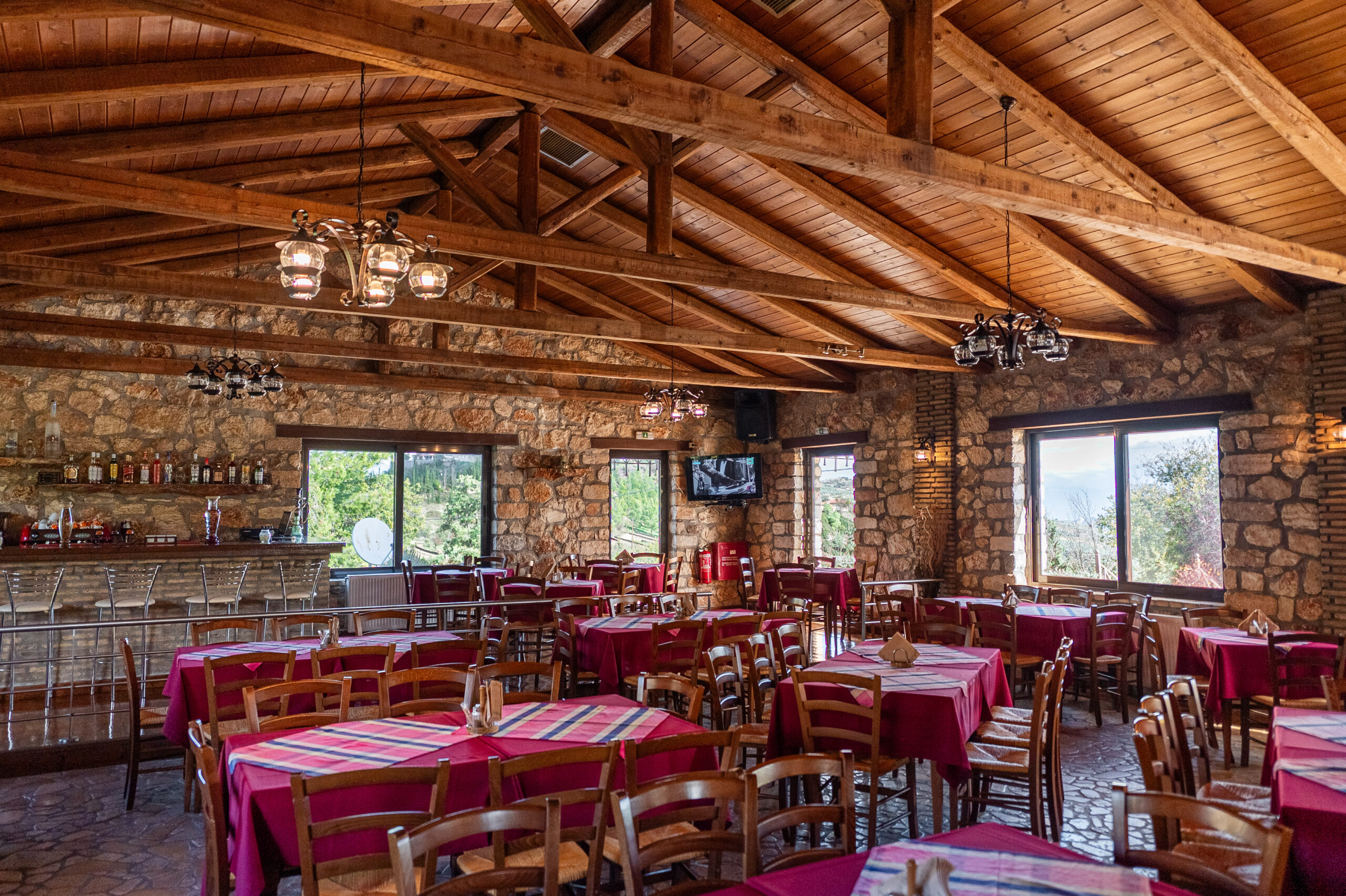 To Polychoro taverna in Trikala, Corinthia: charcoal grill and a fireplace since 2008 1 The main dining hall with its wooden roof and stone walls